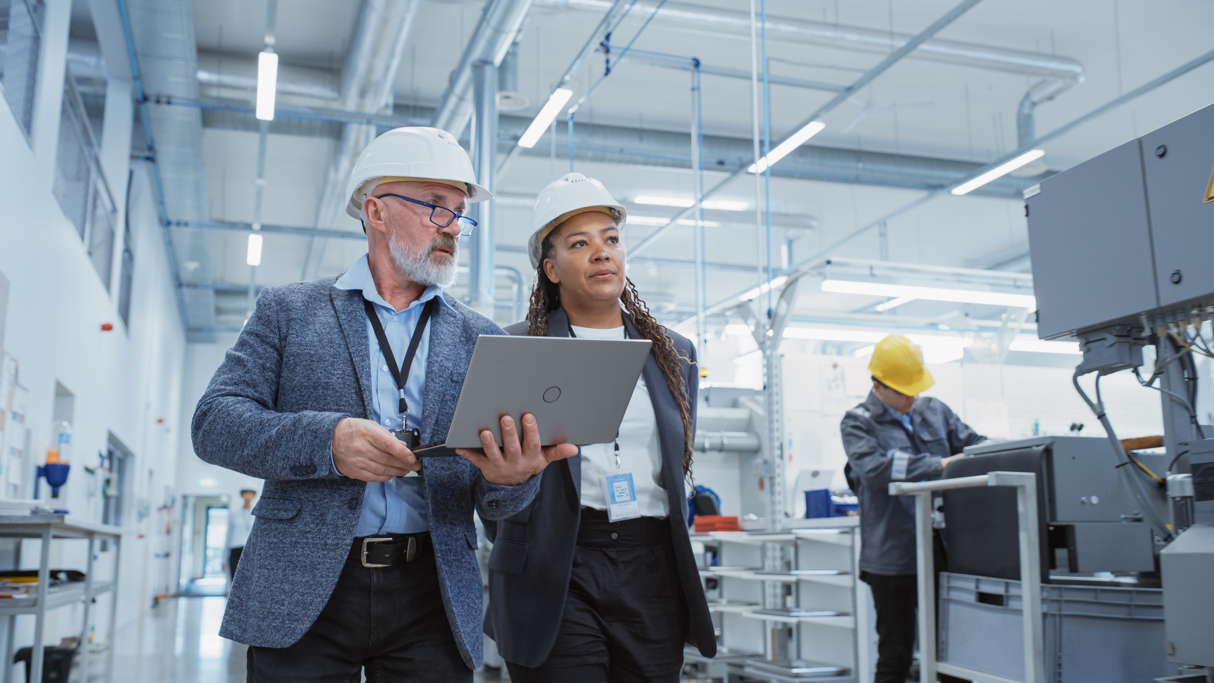 Engineers reviewing a laptop on a factory floor