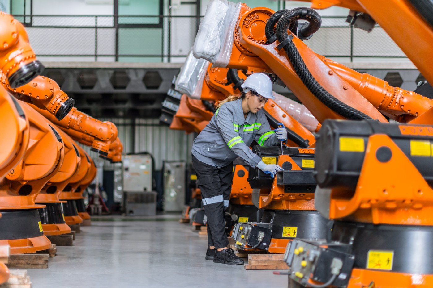 Engineer working with industrial robotic arms